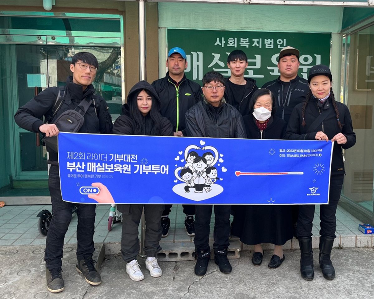 매실보육원 앞에서 기부 활동 현수막을 들고 모인 참여자들